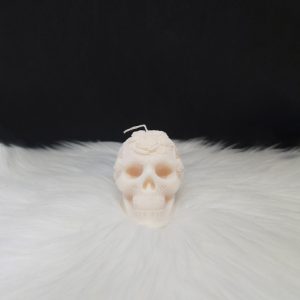 Bougie décorative crème en forme de crâne avec fleurs incrustées sur le dessus