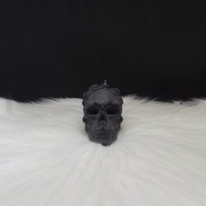 Bougie décorative noire en forme de crâne avec fleurs incrustées sur le dessus