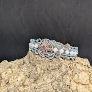 Bracelet en macramé de couleur bleu gris, médaillon central arbre de vie en alliage métallique orné de deux petites perles en inox argenté et agrémenté de pierres naturelles rondes en howlite blanche.
