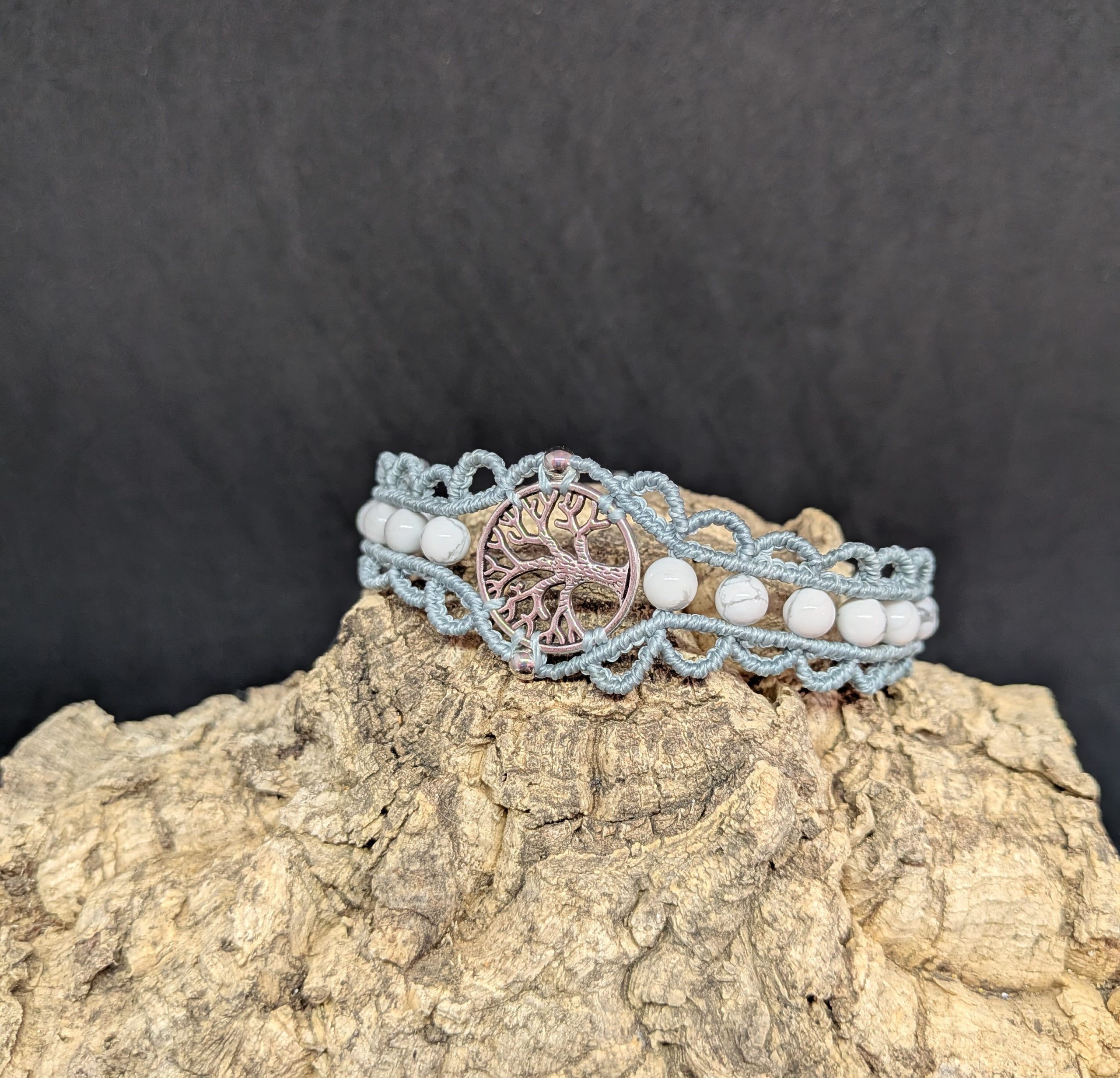 Bracelet en macramé de couleur bleu gris, médaillon central arbre de vie en alliage métallique orné de deux petites perles en inox argenté et agrémenté de pierres naturelles rondes en howlite blanche.