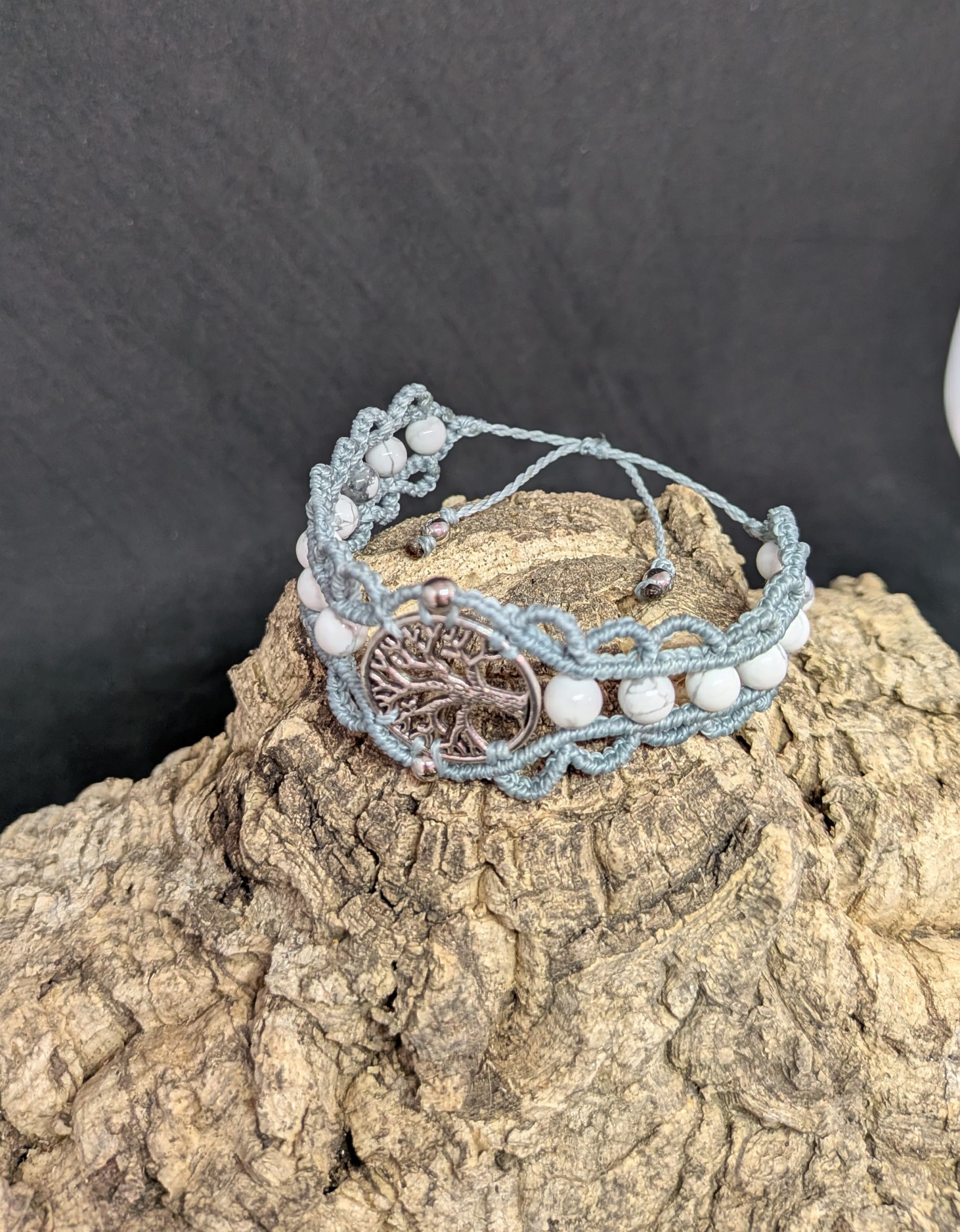 Bracelet en macramé de couleur bleu gris, médaillon central arbre de vie en alliage métallique orné de deux petites perles en inox argenté et agrémenté de pierres naturelles rondes en howlite blanche.