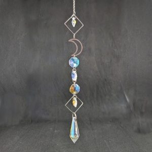 Attrape soleil composé d'une chaine de métal, de losanges , d'une demi-lune en métal argenté, le tout agrémenté de cristaux de forme octogonale et d'un cristal en forme de pendentif.